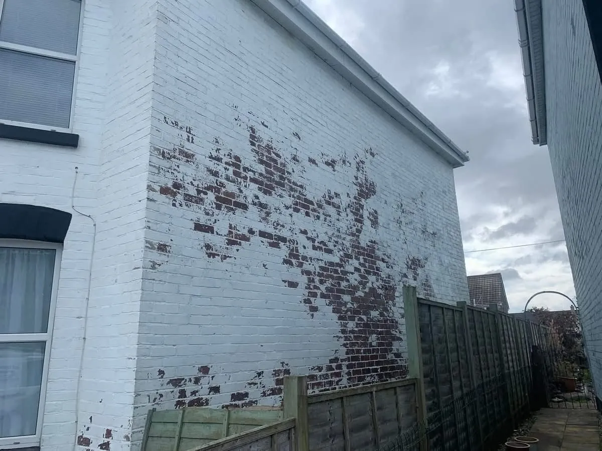 Peeling paint on a brick wall before redecoration in Kingsteignton